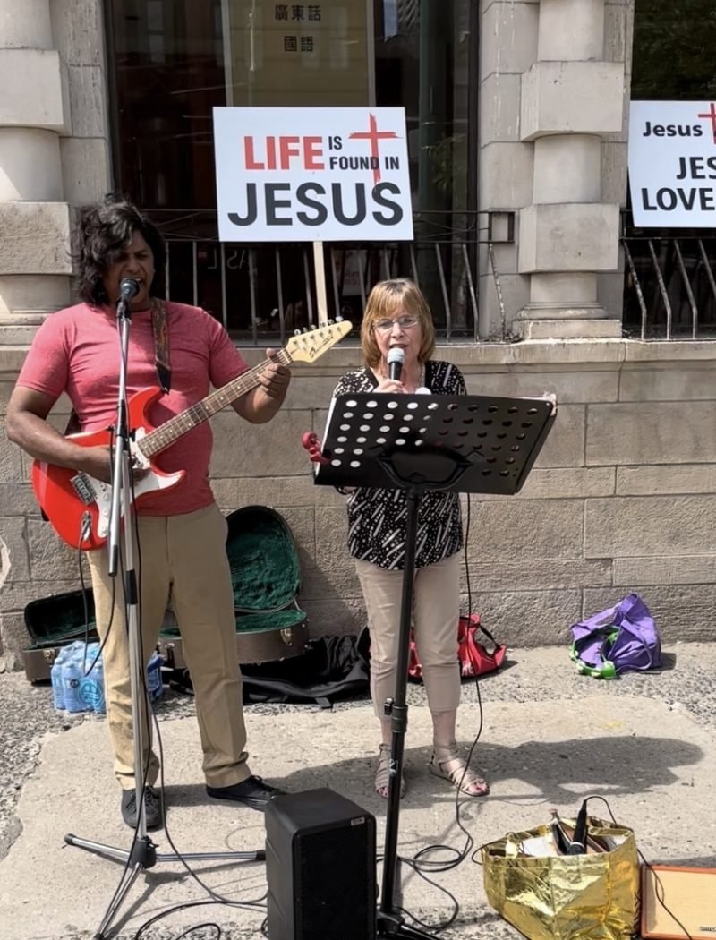 Street musicians performing with religious signs outdoors